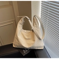 Borsa hobo minimalista color crema con tracolla regolabile in un ambiente moderno - Bianco Sporco