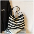 Detail of black and white striped woven tote with mesh texture and horn buckle closure - Black