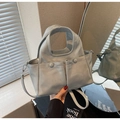 Dettaglio di una grande borsa tote grigio chiaro con tasche anteriori e riflessi a specchio - Blu