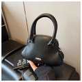 Close-up of black pebbled leather mini shell bag with silver hardware and dual handles - Black