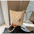 White quilted bucket bag with silver heart pendant and thin shoulder strap in hand - Off-white