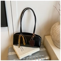 Close-up of black retro baguette bag with leather texture and silk ribbon details on books - Black