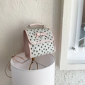 Bolso bandolera rosa y beige con estampados de lazos negros y colgante de corazón de metal - Blanco