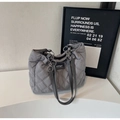 Grey quilted tote bag with diamond pattern and silver metal rings on a white pedestal - Gray