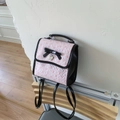 Mochila rosa y negra con patrones grabados y un elegante detalle de lazo negro - Rosa