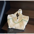 Handmade cream knit tote bag featuring contrasting green wavy trim on wooden stairs - White