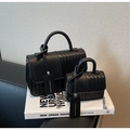 Detail of black woven leather handbag set with silver chain strap on white magazine - Black Large