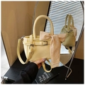 Detailed macro view of cream yellow leather handbag with polka dot silk scarf and strap - Yellow