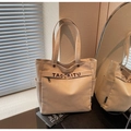 Detail of canvas tote bag showing embroidered TAOCAITU logo and front zipper pocket - Khaki
