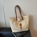 Handwoven straw tote bag in light beige with brown leather handles and front pocket detail - Off White