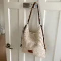 Detailed macro of hollow crochet knit texture and wooden bead shoulder straps - Off White