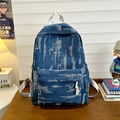 Distressed dark blue denim backpack with unique rip textures and silver grey straps - Blue
