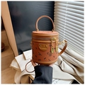 Detailed close-up of brown pebbled leather bucket bag with cute bear print and gold charm - Brown