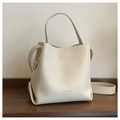 Detailed close-up of cream-white litchi grain leather and embossed logo on bucket bag - Off White