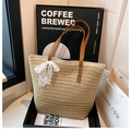 Beige large straw tote bag with brown handles and a white lace bow charm - White