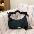 Black ruched shoulder bag with scrunchie strap and minimalist logo on white background - Black