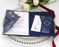 Detail of navy blue laser-cut lace wedding invitation set on a decorative plate - Ink Blue