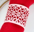 Close-up of laser-cut pink hollow napkin ring with elegant floral scroll patterns - Pink