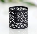 Detail showing laser-cut black matte paper napkin ring with intricate hollow floral patterns - Black