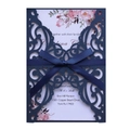 Detail of navy blue laser-cut wedding invitation with silk ribbon bow and floral insert - Magic Blue