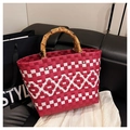 Detail of red and white woven tote bag featuring natural bamboo U-shaped handles - Red