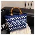 Detail of blue and white checkered woven tote bag featuring natural bamboo handles - Blue