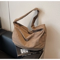 Dettaglio della borsa tote in nylon marrone caffè con trama pieghettata contro un muro - Marrone