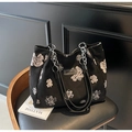 Black canvas tote bag with white floral patterns and silver chain handles in artistic style - Black