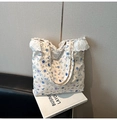 Detailed view of floral tote bag featuring elegant white lace trim and blue floral patterns - Blue Flower