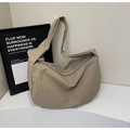 Borsa a tracolla in nylon kaki minimalista con tracolla larga in un ambiente da studio - Cachi