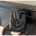 Detail of black nylon tote bag featuring adjustable leather strap and silver metal trim - Black