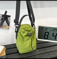 Detailed close-up of a neon green drawstring bucket bag with black adjustable strap and cord - Green