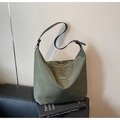 Macro shot of olive green nylon fabric texture and adjustable leather strap on hobo bag - Green