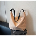 Detail of khaki nylon tote bag with black leather strap on a chair for work - Khaki