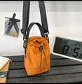 Detail of the orange nylon bucket bag with drawstring closure and brand label - Orange