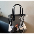 Detail of woven bucket bag with leather handles and pearl lace bow charm - Black