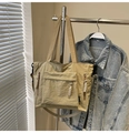 Detail of khaki nylon tote bag with functional exterior pockets and woven rope pulls - Khaki