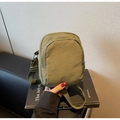 Detalle de la mini bandolera de nailon verde oliva con diseño de varios bolsillos con cremallera - Verde