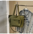 Detail of army green nylon tote bag featuring front flap pocket and woven zipper pulls - Green