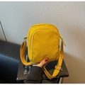 Detalle de bolso bandolera de nailon amarillo con bolsillo frontal con cremallera y correa - Amarillo