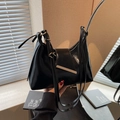 Glossy black leather dumpling bag with silver metal bar detail and slim shoulder strap - Black