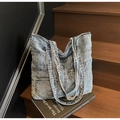 Close-up of vintage blue denim tote bag with multiple pockets on a rustic wooden background - Light Blue