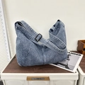 Macrodetail van blauwe denim draagtas met verstelbare gesp en dubbele stiksels - Blauw
