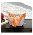 Detail der khakifarbenen Hobo-Tasche mit orangefarbenem Gurt und buntem Anhänger - Grau