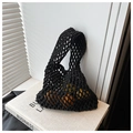 Detail of black crochet mesh tote bag showing capacity with oranges on a book - Black