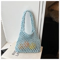 Close-up of light blue hollow knit tote bag with fresh oranges and lemons inside - Blue
