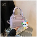 Détail du sac à bandoulière lilas en similicuir avec un pendentif pompon coloré - Avec Pendentif / Violet