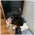 Détail d'un sac oreiller noir brillant avec breloque en peluche et bandoulière amovible - Avec Pendentif / Noir