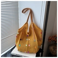 Detalle del bolso de punto amarillo con lentejuelas y asas de cuero marrón - Amarillo