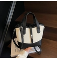 Minimalist color-block bucket bag in black and off-white with lychee grain leather finish - Black and White
